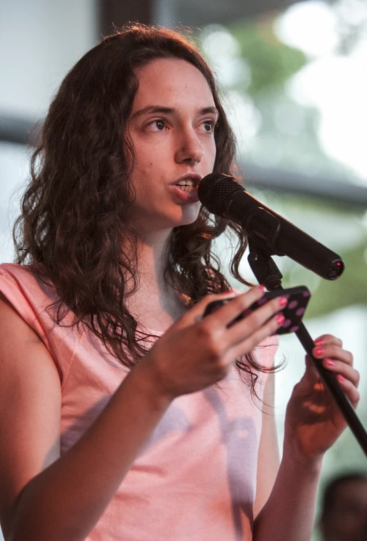 girl singing into a microphone at a public event