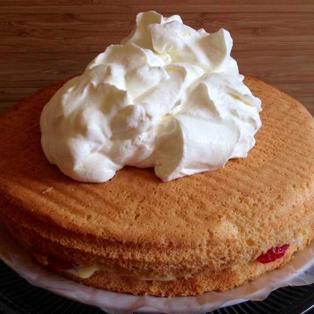 a cake with whipped cream on top sitting on a plate