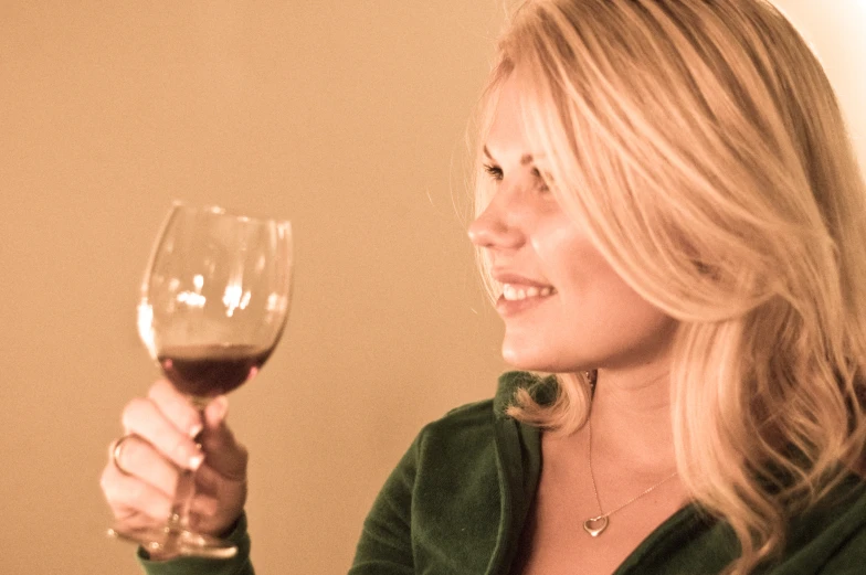 a woman holding a wine glass looking at the camera