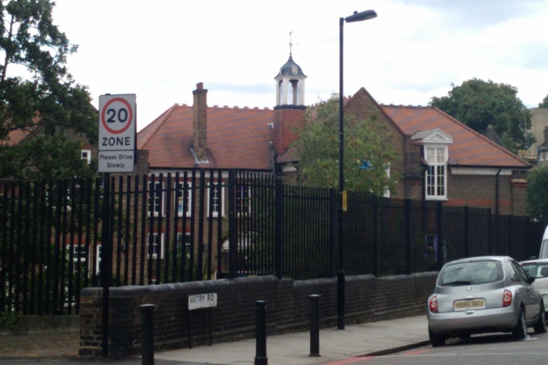 there are several cars that is parked near the fence