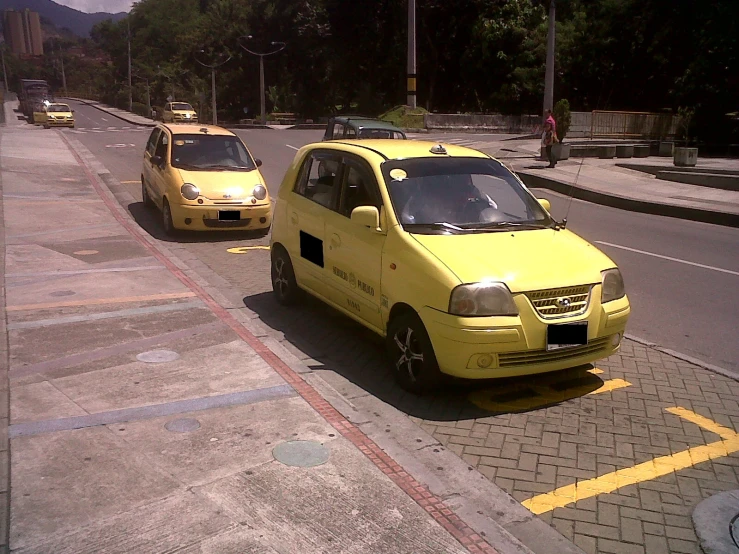 two taxis driving down a city street with mountain views