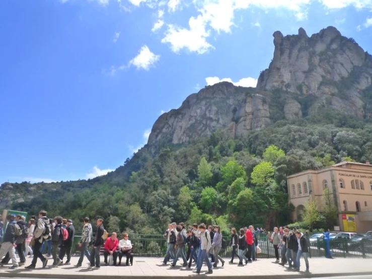 group of people standing together in front of mountains and buildings