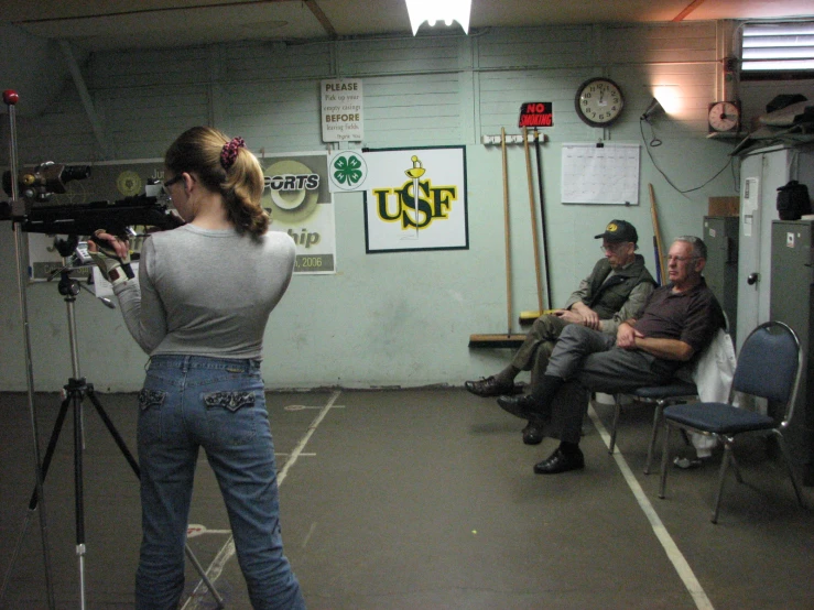 a woman is filming two men in a room