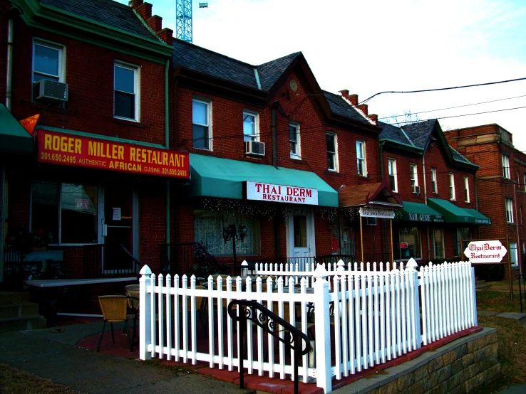 several brick buildings next to a white picket fence