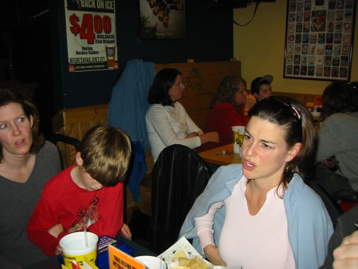 a woman at a table with children eating