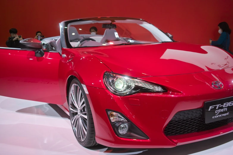 the red sports car is on display at the motor show