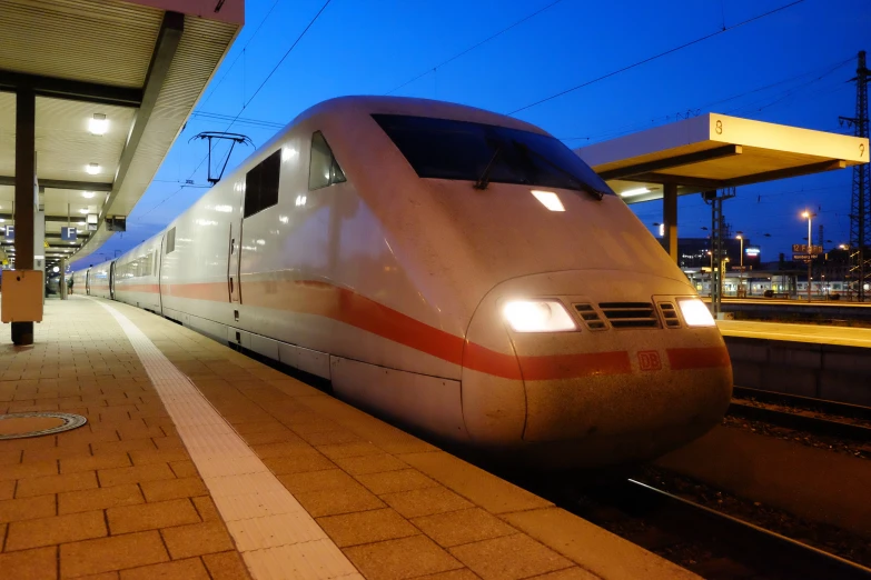 a large white train sitting next to a train station