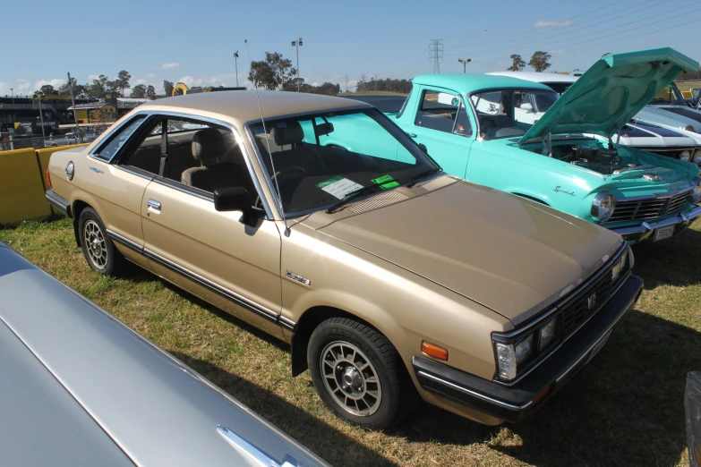 the gold car is parked in front of a green car