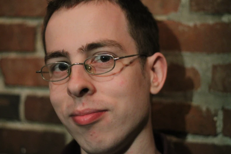 a man wearing glasses and a pink tie looks up