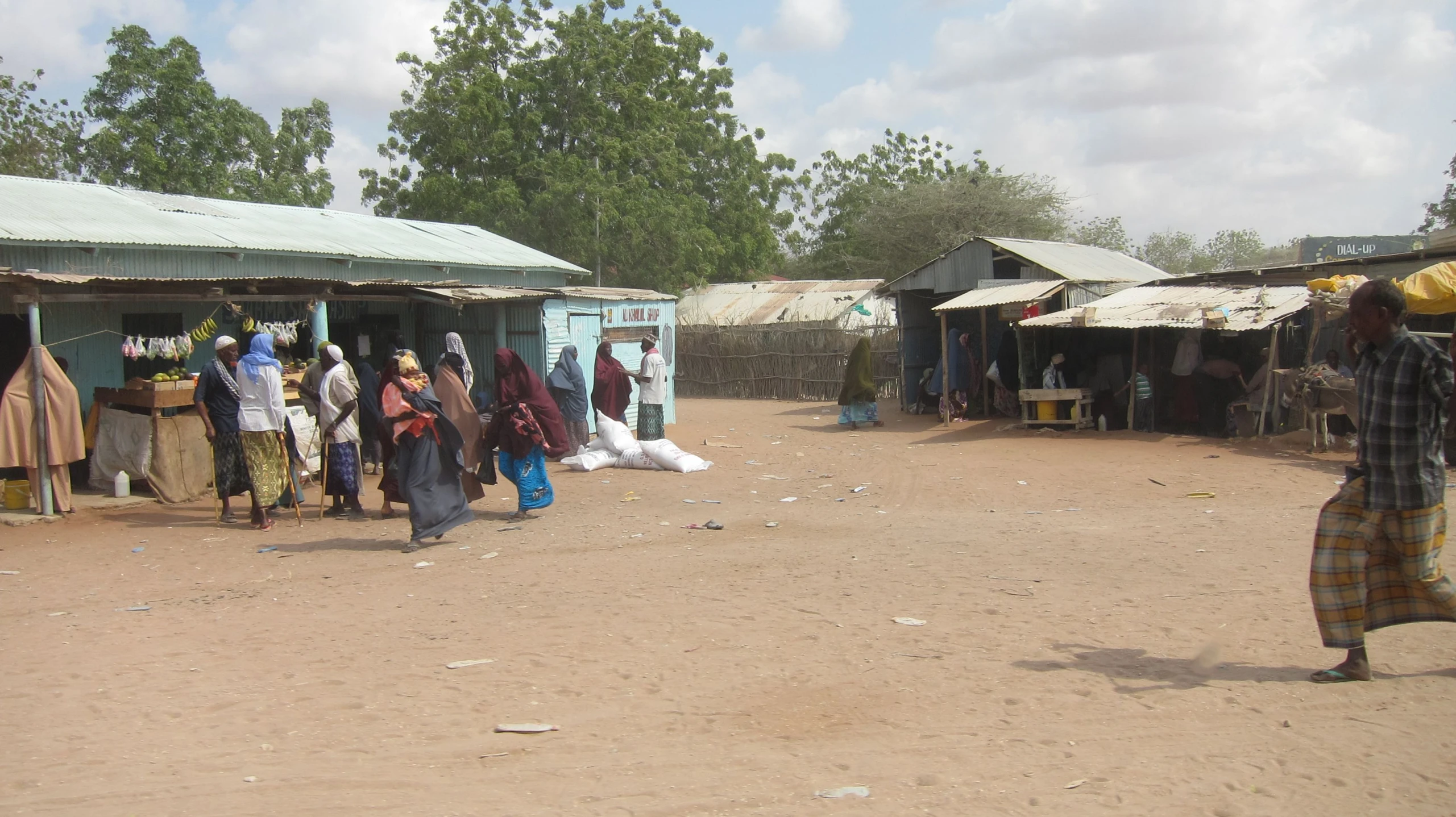 a group of women walking down a dirt road