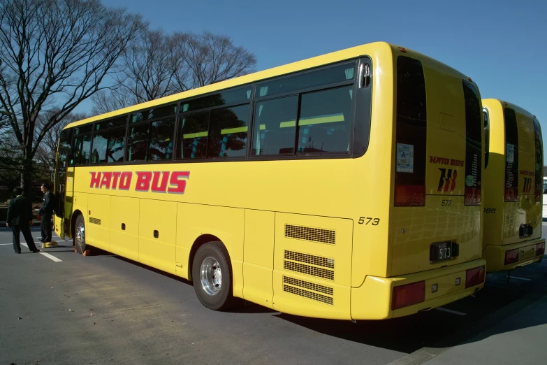 a yellow bus is parked by a street