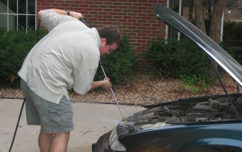 a man looking under a car that is on the ground