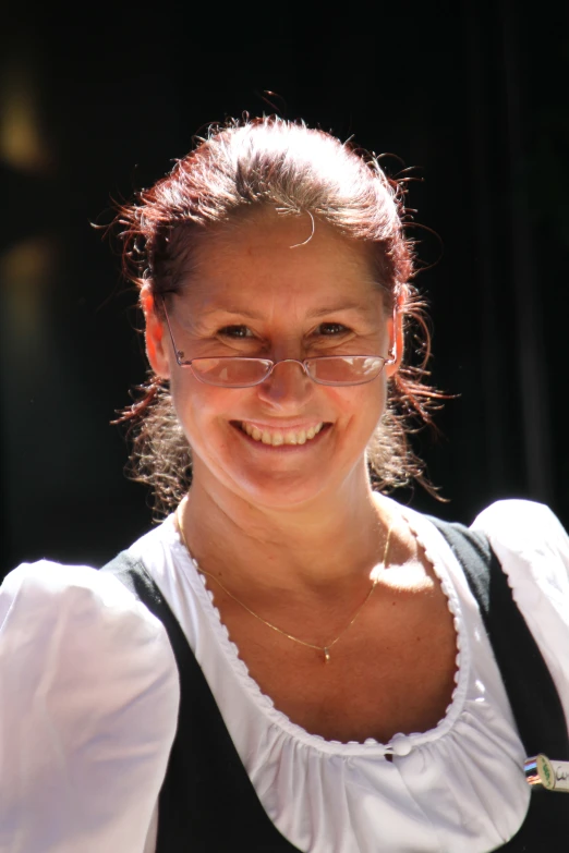 a young woman in glasses is smiling for a camera