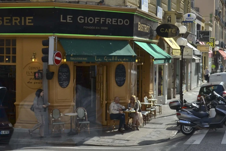 a motorcyclist is parked in front of a restaurant on the street