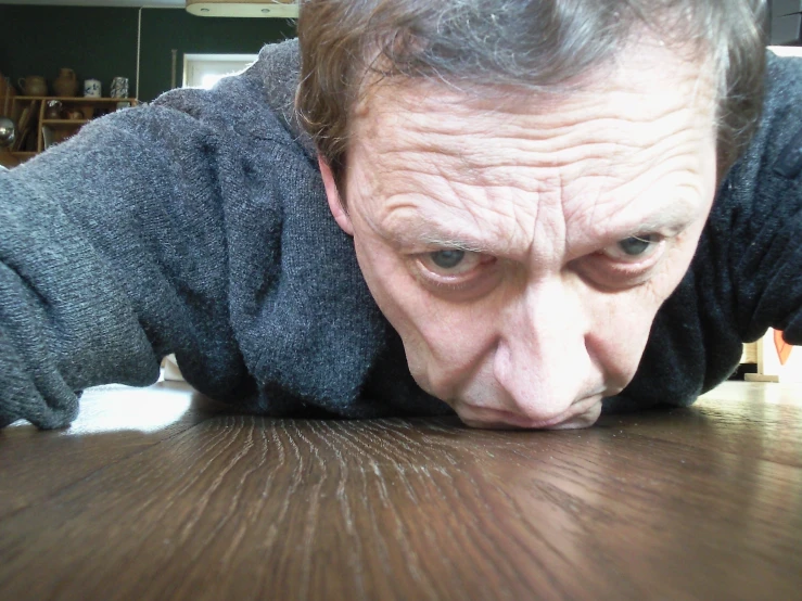 a man on his back on the wooden table