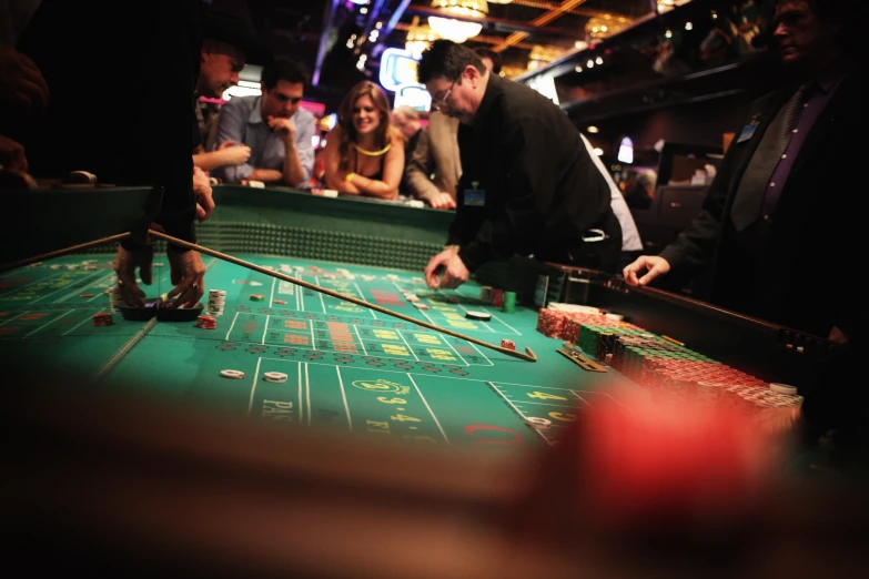 a casino rouleet at the blackjack table, filled with people