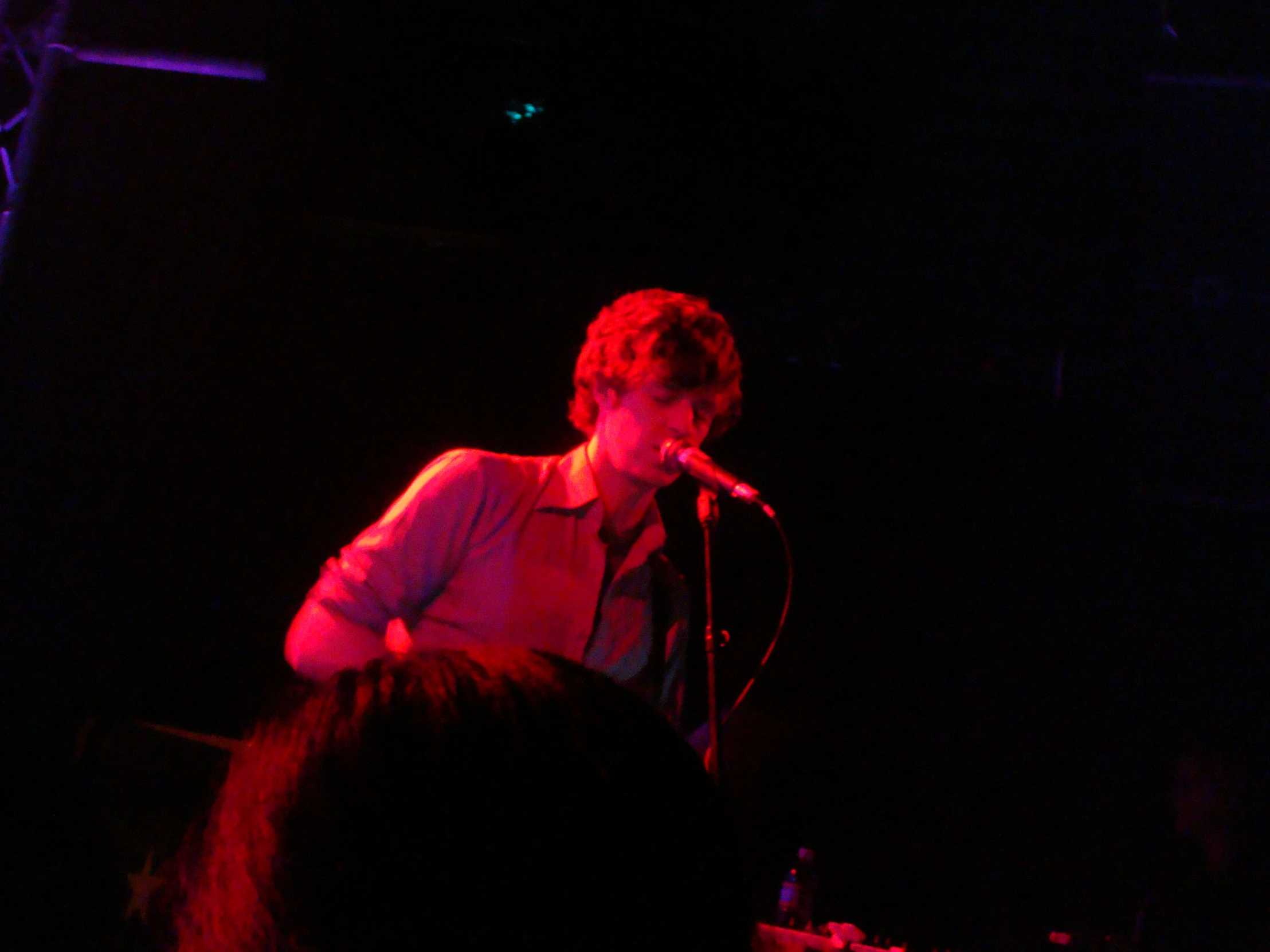 a person holding a microphone while standing in front of a crowd