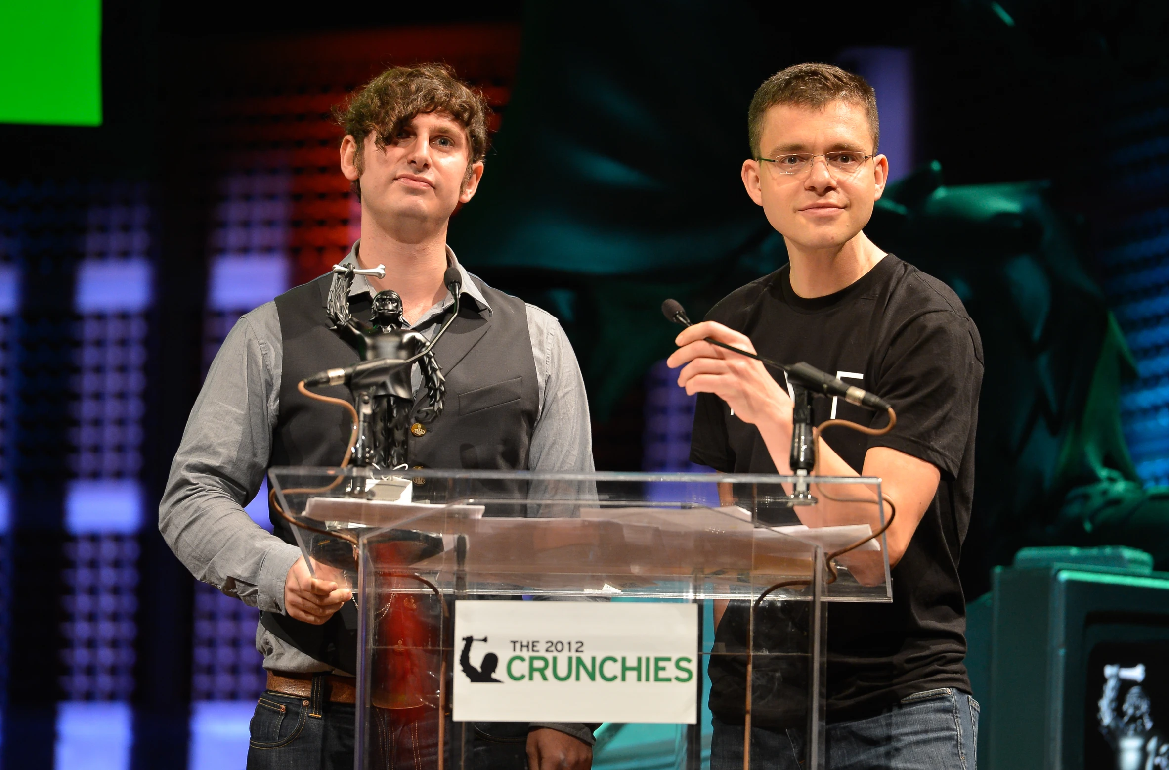 a man that is standing next to another man at a podium