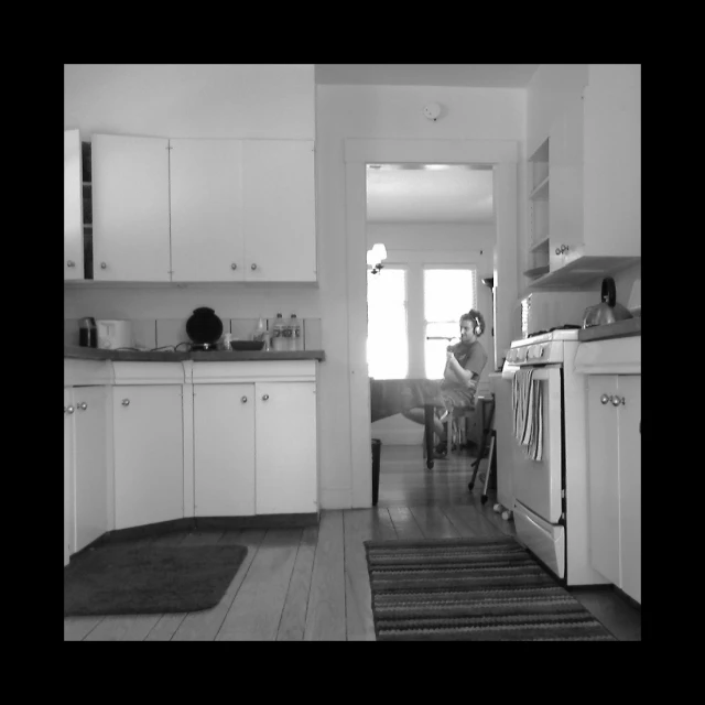 a woman is sitting on the kitchen counter in front of the oven