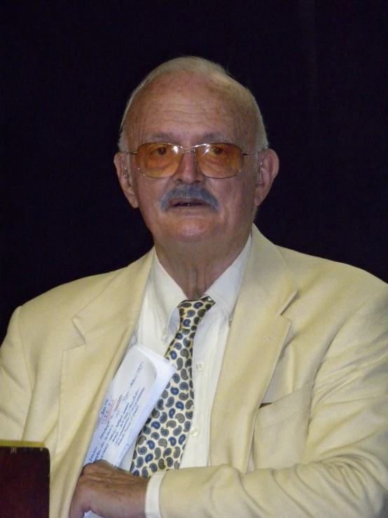 a man wearing a white suit and tie