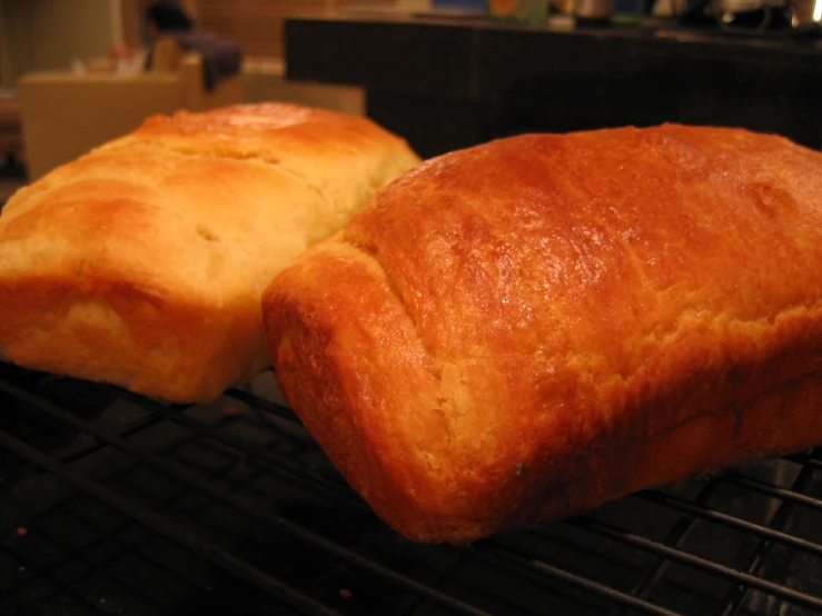 two loaves of bread sit on a barbecue grill