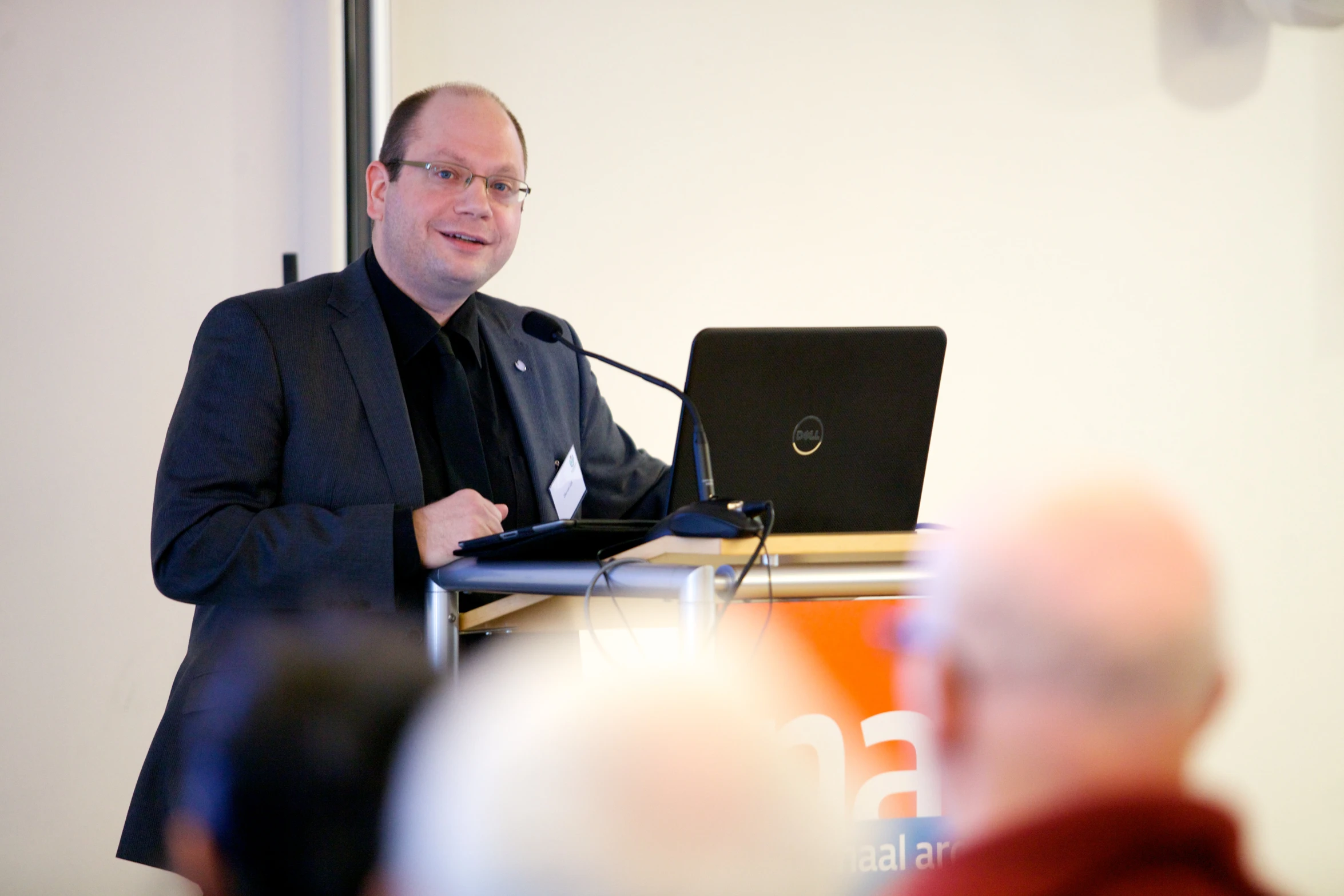 man with laptop in front of onlookers at presentation