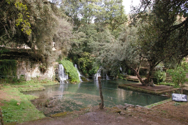 a man - made waterfall and pool on the side of a cliff