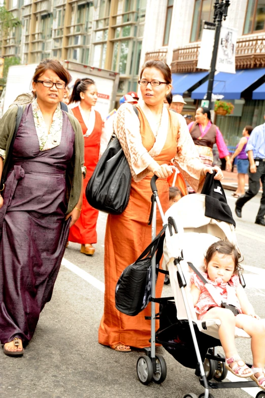 two women in large outfits are walking along the road