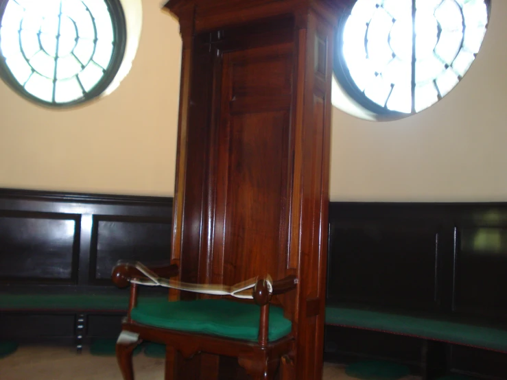 a tall wooden clock tower in the corner of a room