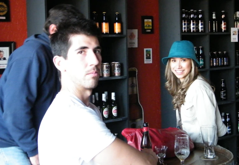 a man and woman sitting at a bar with wine glasses