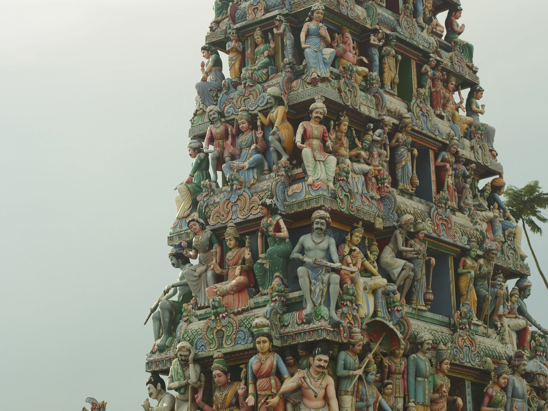 a colorful tower with figurines and statues around it