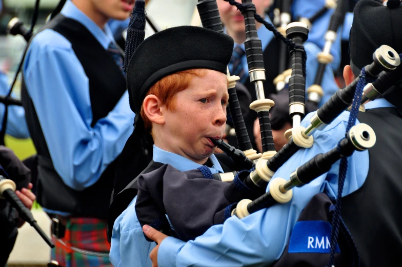 a boy in a school uniform playing pipe players