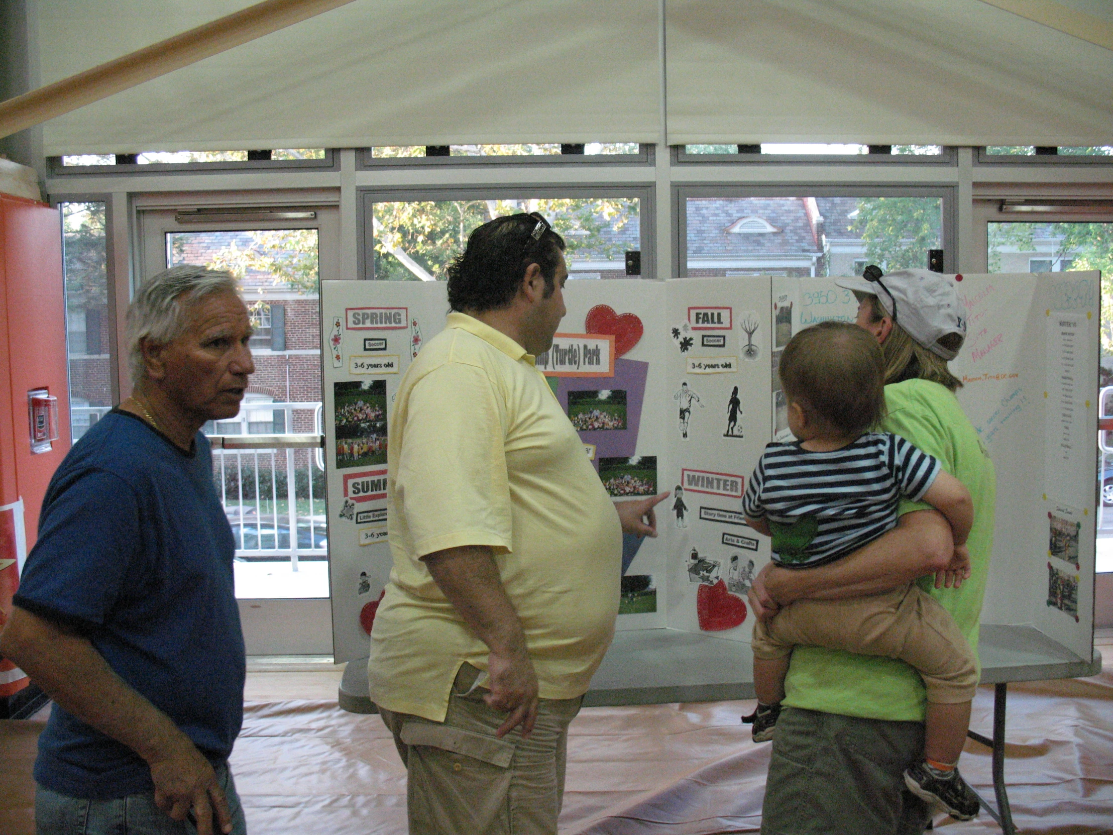 a group of people holding posters together in front of a tent