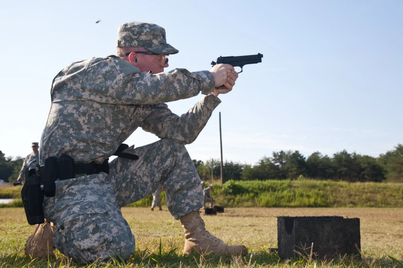 a soldier kneeling down in front of a gun