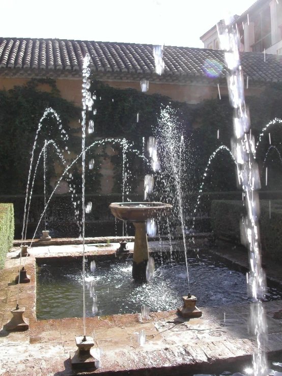 a water fountain in a courtyard with several fountains shooting out of the center