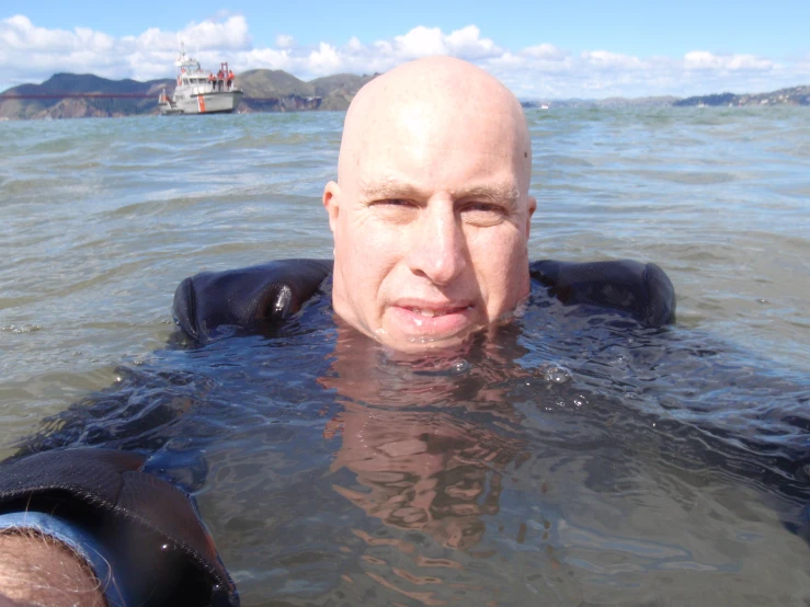 there is a bald man swimming in the water