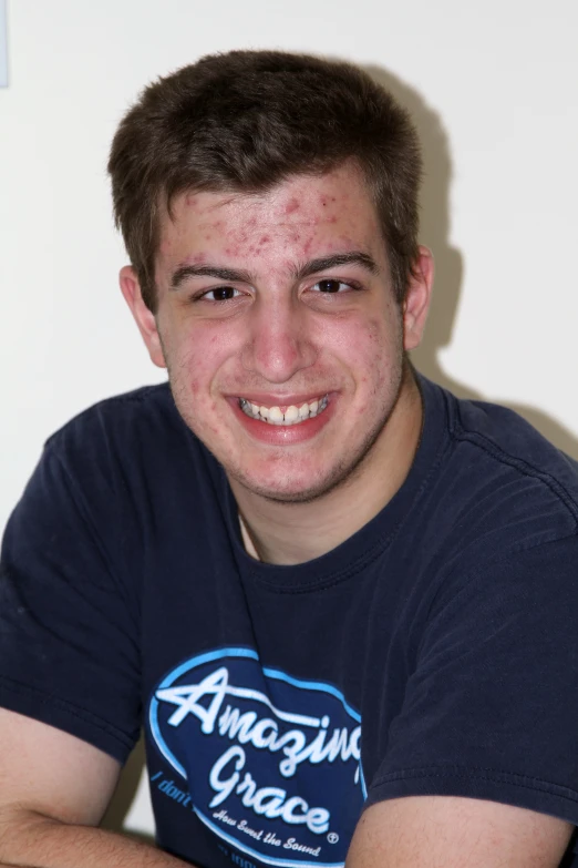 a smiling man in a blue t - shirt with the word amazing grace on it