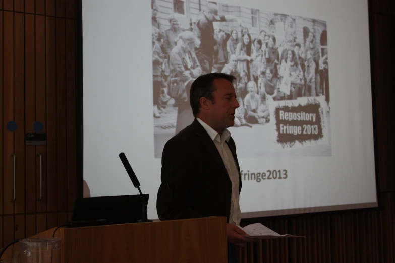 a man is standing at the podium and giving a presentation