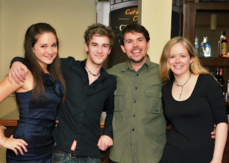 a group of young people standing together smiling for the camera