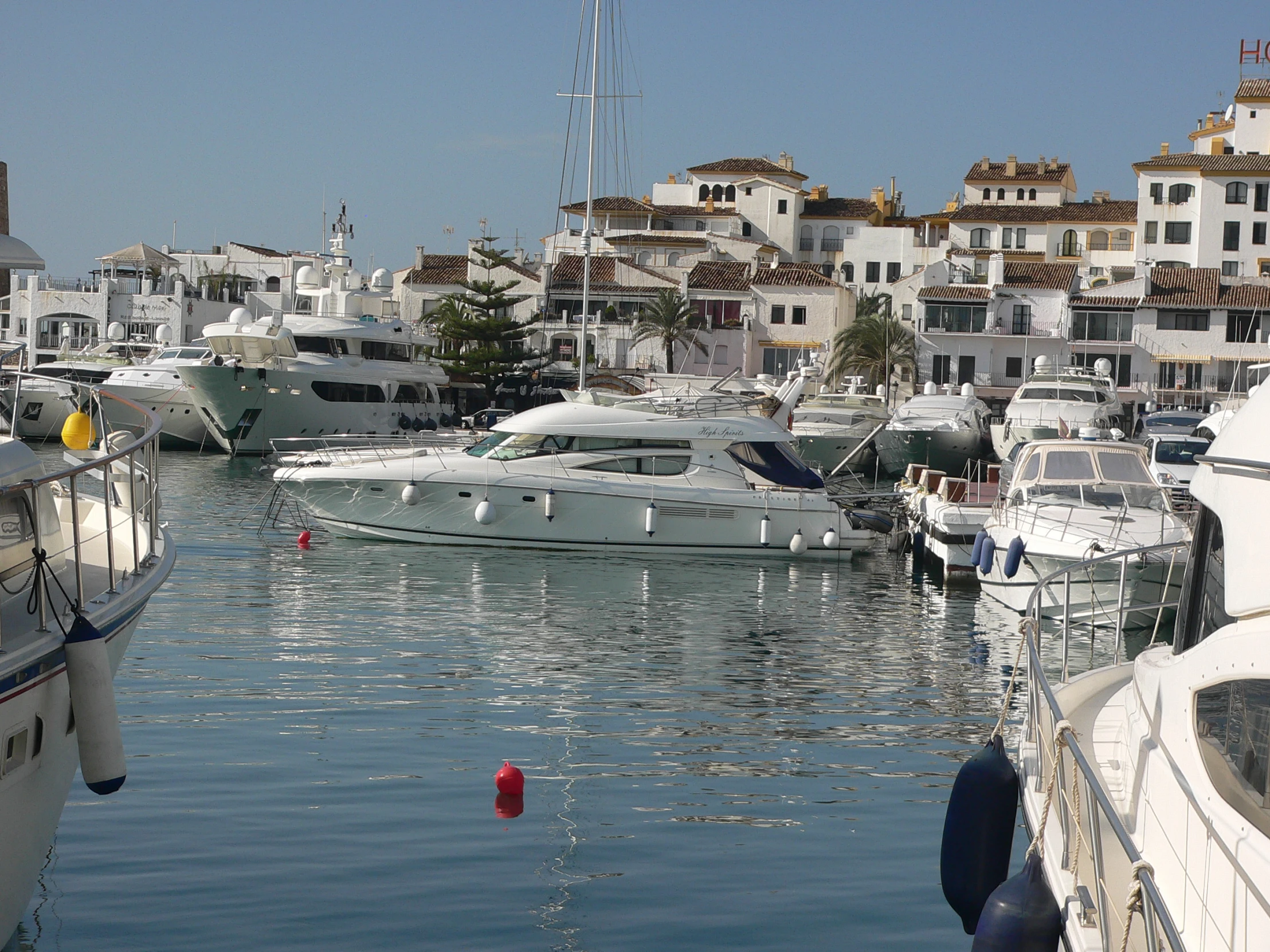a harbor filled with white sailboats next to some buildings