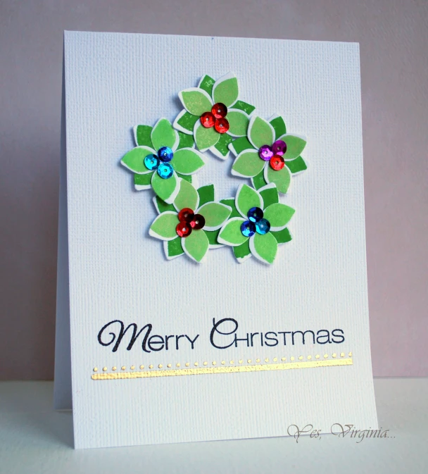 a card with green leaves and some red ons