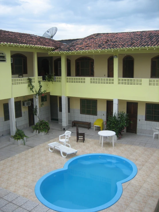 a view of an open air swimming pool with chairs surrounding it