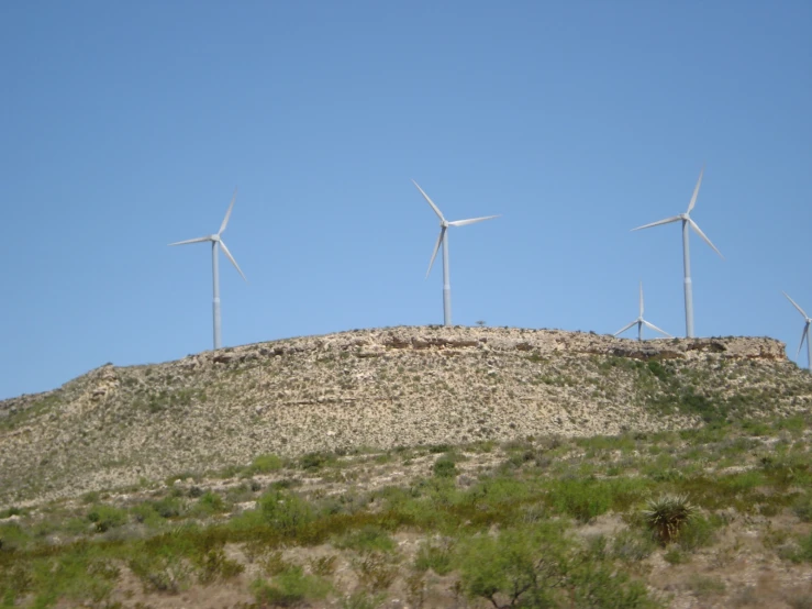 four windmills in the distance on a mountain