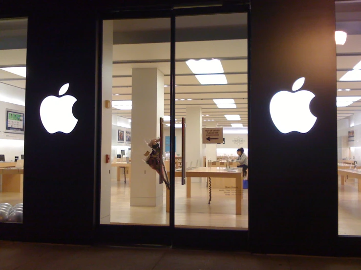 a person walking out of an apple store with their hand up