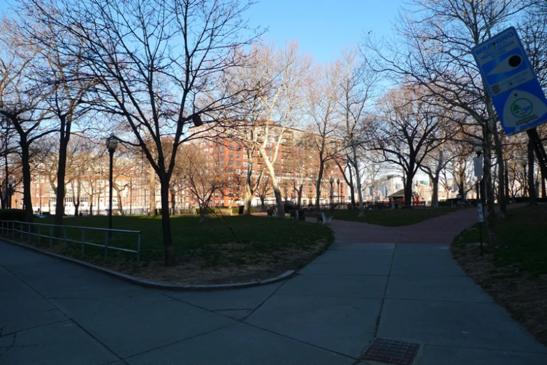 a park area with trees, buildings and walkway