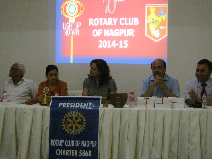 four people sitting around a table with a presentation