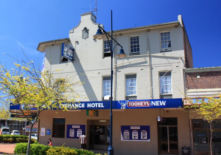 an empty street corner with a building and blue sky