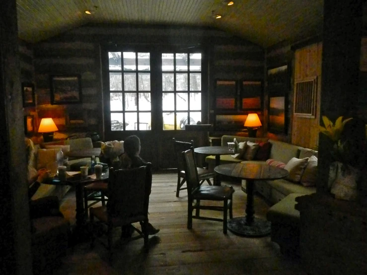 a room with couches and table lamps and windows