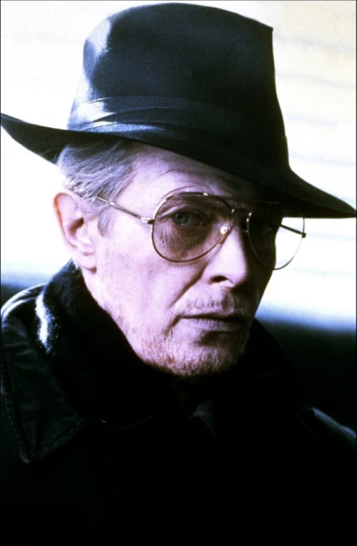 man in a black hat wearing glasses, a jacket and jacket