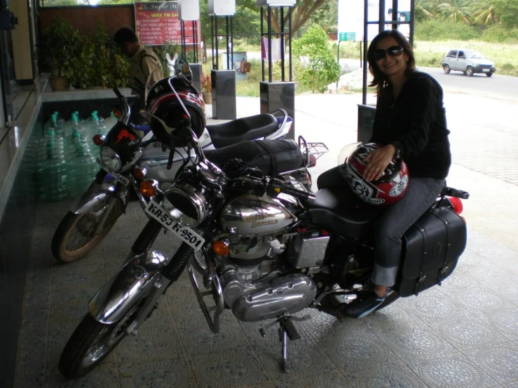 a woman sits on a motorcycle beside another one